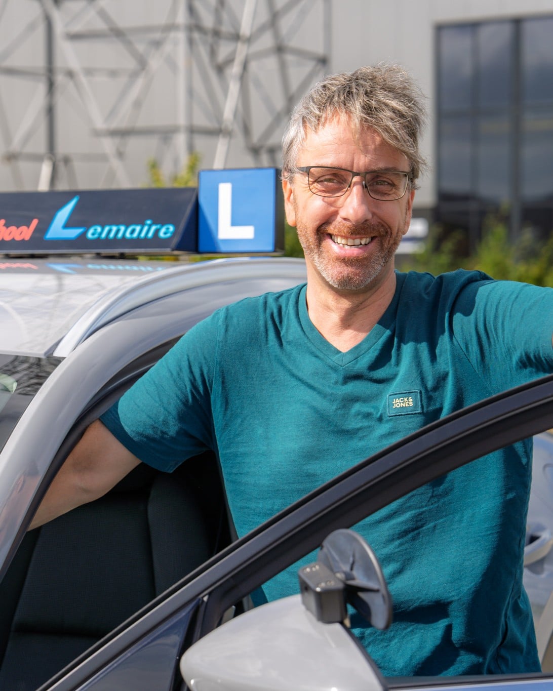 Rijinstructeur in de deuropening van de auto. 